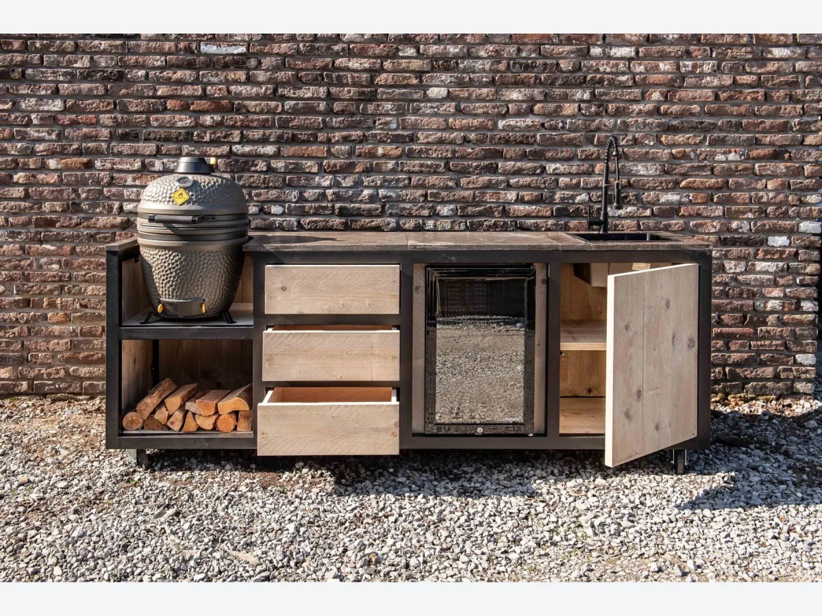HoutenmeubelsXL Kanawa, Buitenkeuken Kanawa 240 cm met kamado en geopende lade en deur, recht van voren voor een bakstenen muur