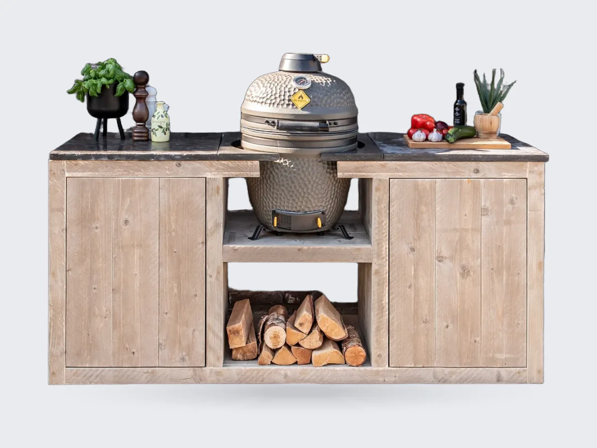 HoutenmeubelsXL Madura, Buitenkeuken Madura 180 cm van steigerhout met hardstenen tegels en een kamado in het middenvak, recht van voren voor een bakstenen muur