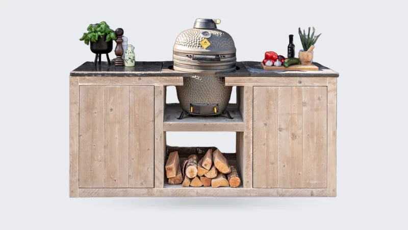 HoutenmeubelsXL Madura, Buitenkeuken Madura 180 cm van steigerhout met hardstenen tegels en een kamado in het middenvak, recht van voren voor een bakstenen muur