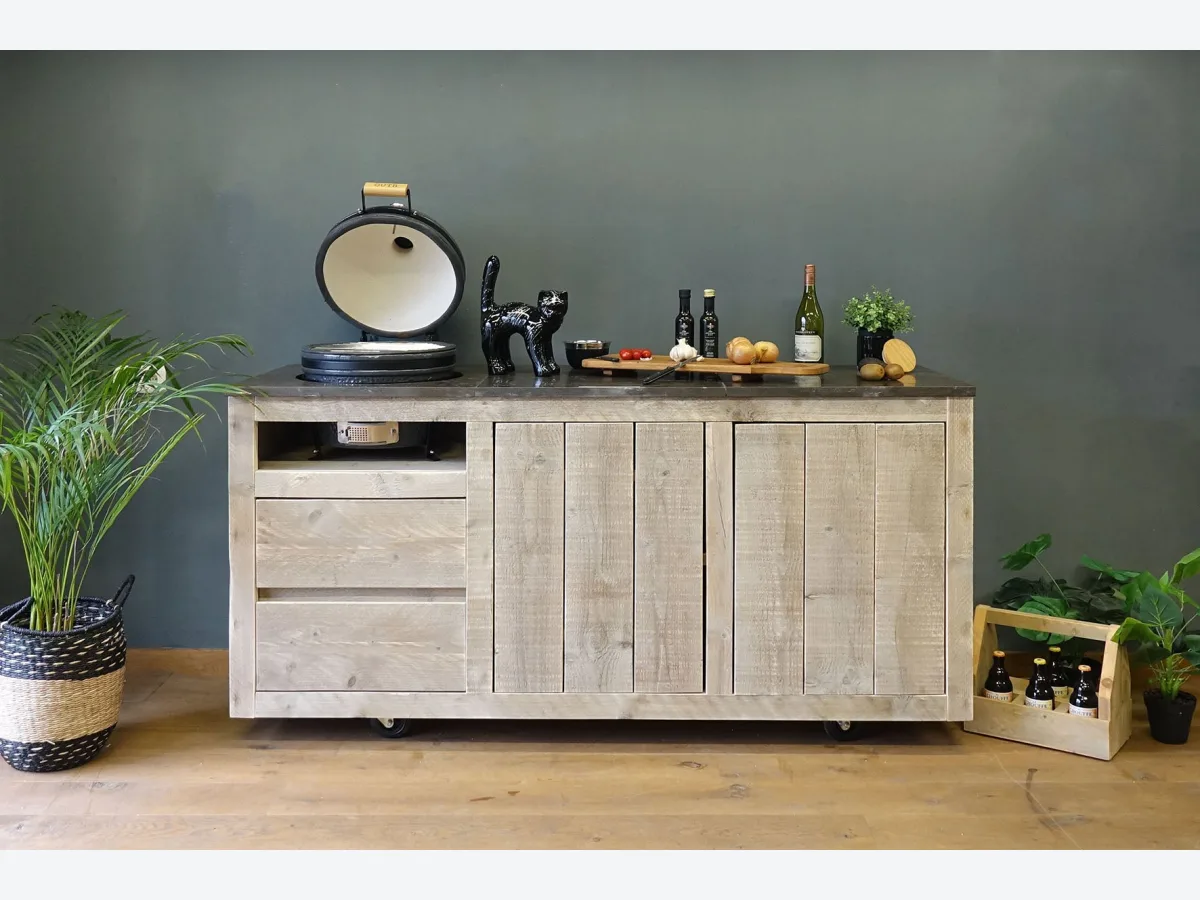HoutenmeubelsXL Manado Mobile, Buitenkeuken Manado Mobile op wielen met geopende kamado links, recht van voren voor een groene wand