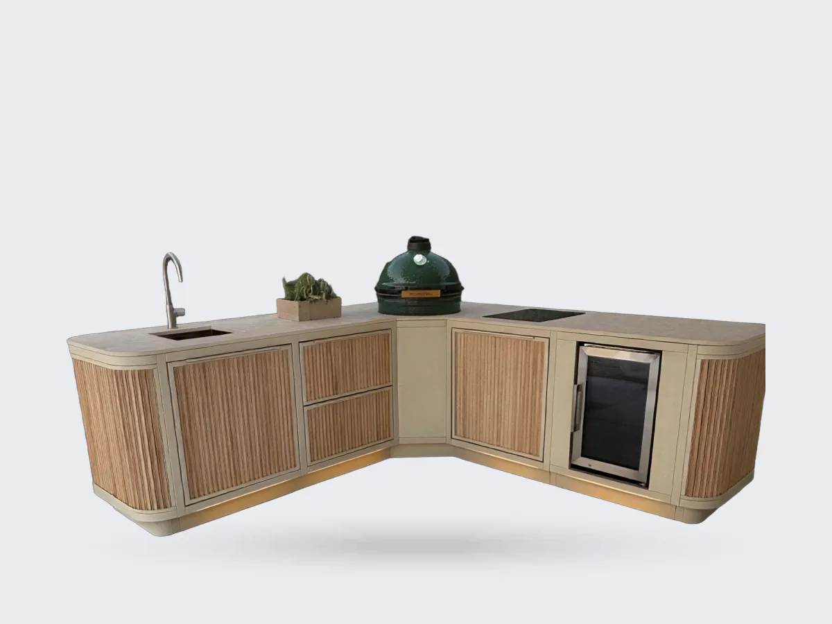 Rêveluxe Sur Mesure, Render van een Sur Mesure hoekopstelling in beige met eiken rondingen, Big Green Egg, spoelbak, kookplaat en koelkast in een tuin met plintverlichting
